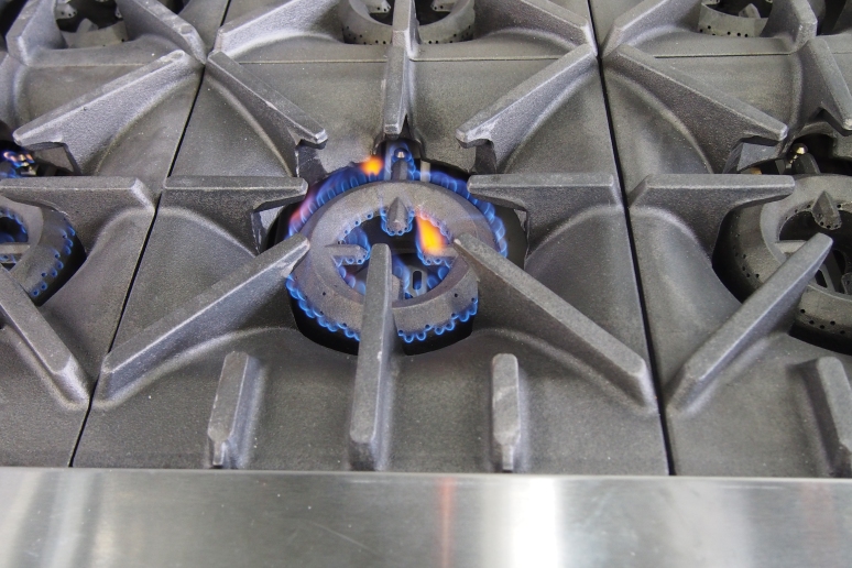 cast iron stove top with natural gas flame burning