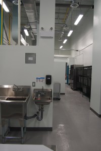 a hallway lit with lights and sinks in the foreground