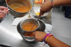 Straining the blended peaches.